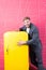 Man formal elegant suit stand near retro vintage yellow refrigerator. Vintage household appliances. Bachelor hungry guy