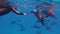 Man free diver capturing group of beautiful dolphins swimming near to him