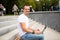 Man freelancer with laptop sitting in urban park