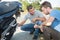 Man and friend repairing damaged motorcycle engine