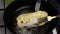 A man fries chicken roll. In a preheated frying pan in butter. For frying from all sides holds the roll with forks