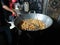 man frying cripsy tofu at big pan, using used cooking oil or minyak jelantah