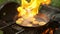 Man frying a slices of zucchini on frying pan with oil and its burning in fame.