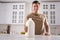 Man with gallon bottle of milk at white marble table in kitchen