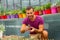 Man gardener holds a pot in his hand and examines the seedlings of mammillaria cacti. Growing and caring for plants and flowers in