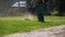 Man Gardener Mows the Grass on the Lawn using a Gasoline Mower in the Park. Slow Motion