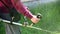 Man gardener mows the green grass, holding in the hands of a gasoline lawn mower