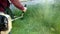 Man gardener mows the green grass, holding in the hands of a gasoline lawn mower