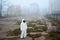 Man in gas mask and protective clothing on football pitch.