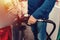 man at the gas station filling the tank of his car with diesel to the top level before a long journey