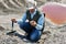 Man geologist examines a rock sample in a desert area