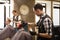 Man getting haircut by hairstylist at barbershop