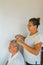 Man getting a haircut with his wife at home. Wife cuts her husband`s hair at home in a pandemic situation