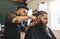 Man getting trendy haircut in barbershop