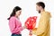 Man gifting bouquet of red paper cut cards with hearts symbols to pretty smiling girl isolated on white