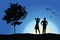 Man and girl standing on hill near tree