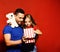 Man and girl with white teddy bear on red background