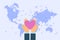 Man give heart in palm hands at world map background. Charity and donation concept illustration in flat style.