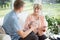 Man giving medications to older woman