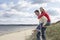 Man giving woman piggy back on dunes