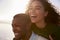 Man Giving Woman Piggyback On Winter Beach Vacation