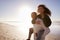 Man Giving Woman Piggyback On Winter Beach Vacation