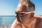 Man with glasses diving and silicone ear plugs on beach