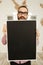 Man in glasses holding blank blackboard in hands