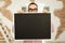 Man in glasses holding blank blackboard in hands