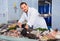 Man in glove behind counter shows fish in his hand