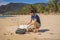 Man in gloves pick up plastic bags that pollute sea. Problem of spilled rubbish trash garbage on the beach sand caused