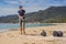 Man in gloves pick up plastic bags that pollute sea. Problem of spilled rubbish trash garbage on the beach sand caused