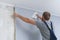 Man glues gray vinyl wallpaper on a non-woven backing. Renovation of the room.