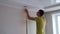 A man glues wallpaper to the wall.