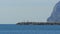 Man goes to the Lighthouse, around it Flies a Flock of Seagulls on the Beach. Gibraltar. Spain.