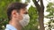 Man goes to work in city on street in medical mask. face shield on young man outdoors in park. man tourist protecting