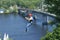 Man going down the zipline taking picture with mobile phone, Truhanov island and Pedestrian bridge on a background