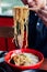 Man grab ramen noodle out of bowl by chopsticks from Shoyu Chashu Ramen by his hand