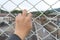 Man grasp the bar of cage with the defocus of city background