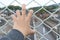 Man grasp the bar of cage with the defocus of city background