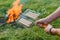 A man with a grate in his hand prepares sausages on the fire. Picnic in nature