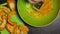 A man grates slices of orange pumpkin. Close-up shot from above