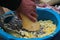 Man grates a squash. Hands hold grater and vegetable