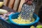 Man grates a squash. Hands hold grater and vegetable