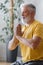 man with gray hair meditates and does breathing exercises. sports fitness and physical exercises for the elderly