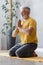 man with gray hair meditates and does breathing exercises. sports fitness and physical exercises for the elderly