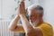 man with gray hair meditates and does breathing exercises. sports fitness and physical exercises for the elderly