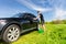 Man with Green Bucket Washing Car in Green Field