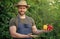 man greengrocer in straw hat presenting bell pepper