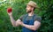 man greengrocer in straw hat presenting sweet pepper